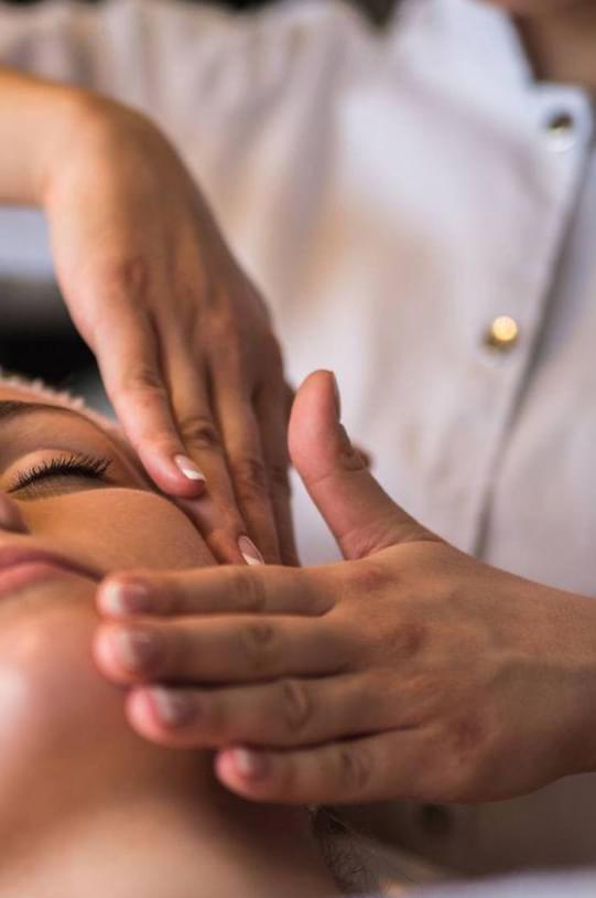 Chica recibiendo un masaje facial relajante con técnica coreanas